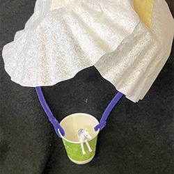 Parachute made out of coffee filters, pipe cleaners and paper cup carrying a small plastic zebra